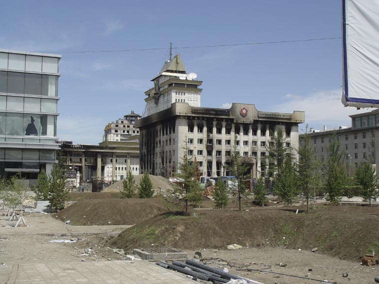 Фотография. Сгоревшее здание Монгольской народной Революционной партии (МНРП). На заднем плане видно обгоревшее здание Центрального дворца Культуры.